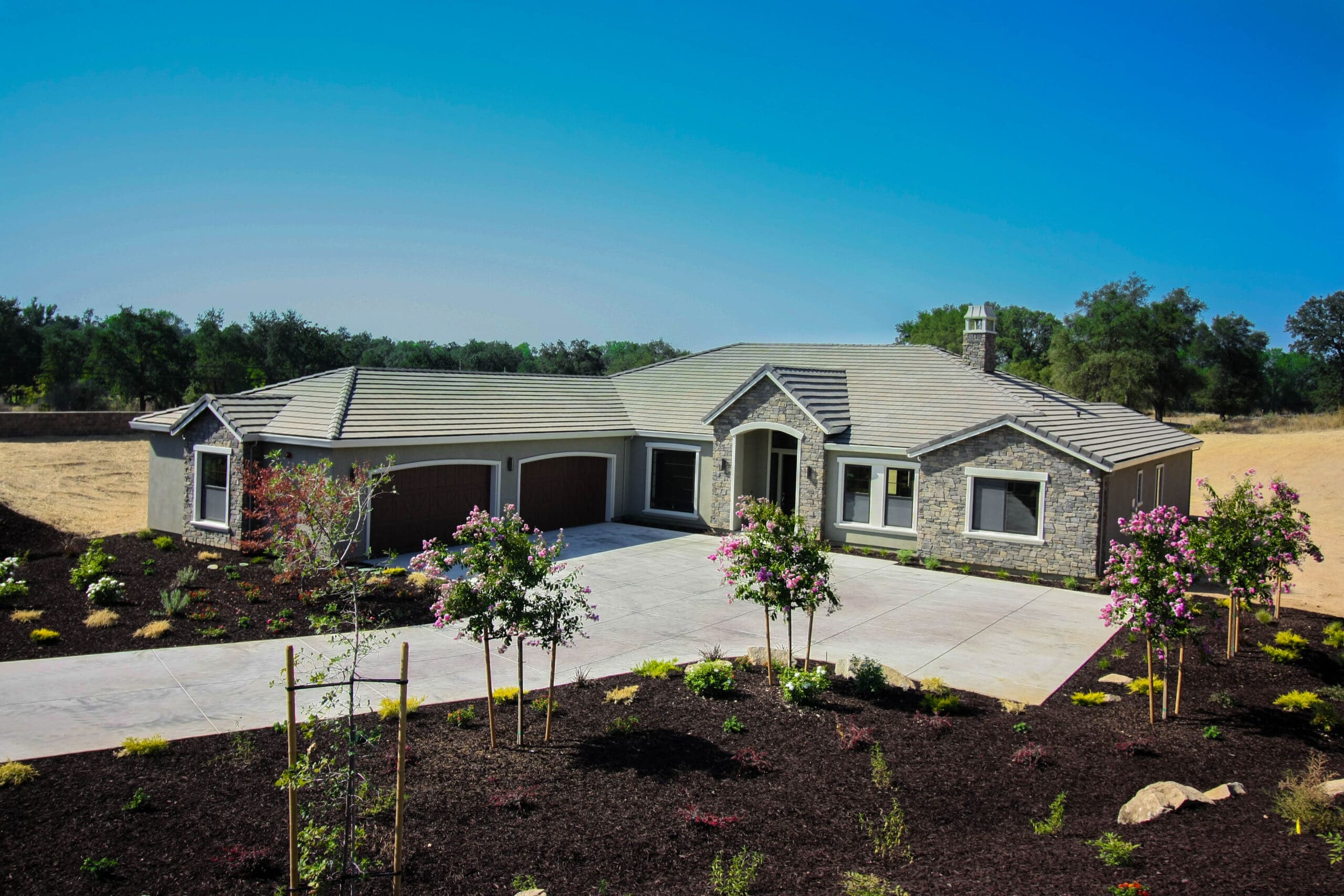 Texas Hill Country custom home under construction with hills and limestone terrain